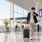 国内線出発前に空港で時刻を確認する旅行者