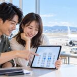 空港で国内線の座席表から隣席を選ぶ旅行者