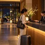 夜遅くホテルのフロントでチェックインする旅行者