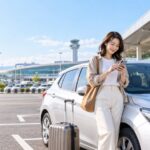 空港近くの営業所でレンタカー予約を確認する旅行者